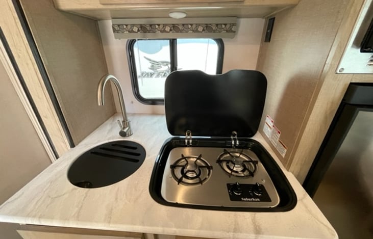 Kitchen sink and the compact 2-burner stove top provides efficient cooking capabilities for delicious meals on the go.