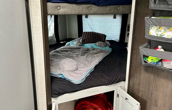 2 full- sized bunks with USB outlets and shelves in both. Drapes can fold and snap up. Huge storage compartment under the bottom bunk that goes all the way back.
