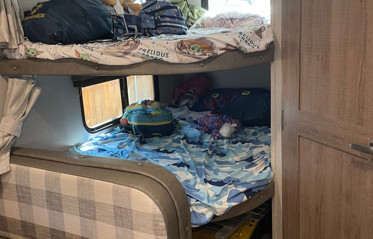 Bunk Beds with kids sheets and pillows.