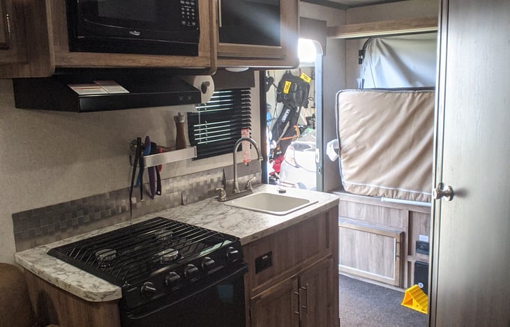 3 burner stove, microwave, and oven.  Hot water sink. Silverware, pots and pans provided.