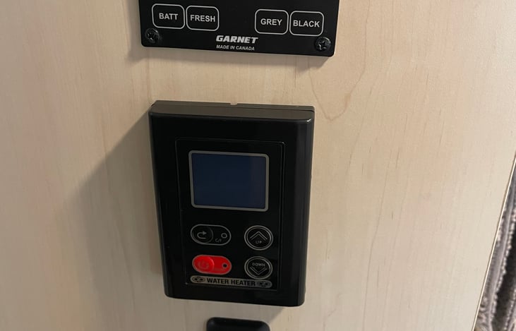 Main control panel, bathroom light switch, water heater on/off switch with temp adjuster, and tank level check.