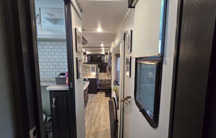 View from bedroom door, past bathroom, through kitchen, to living room