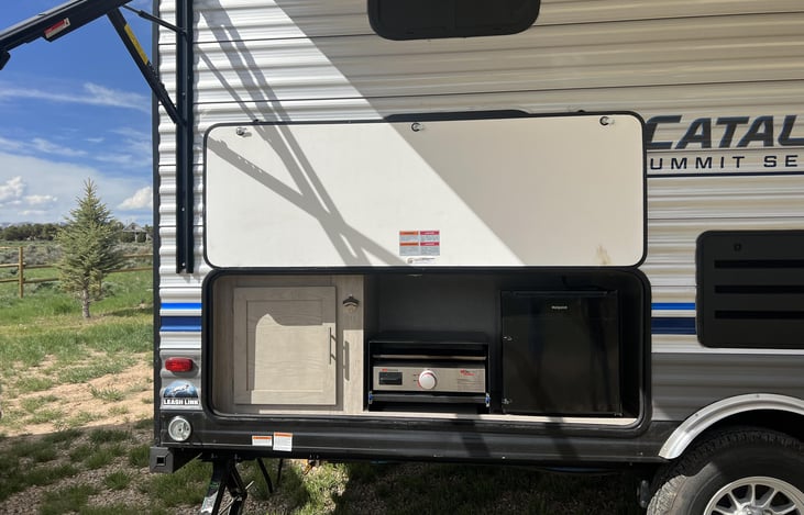 Outdoor kitchen with a fridge, cook top, and pantry.
