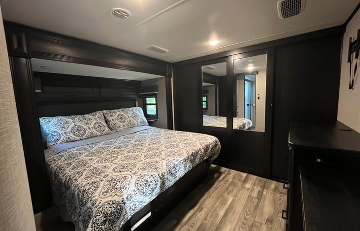 Master Suite includes private door to full bathroom,  king bed, under bed storage, dresser, and large closet behind the sliding glass doors as well as a desk.