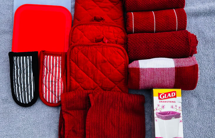 Kitchen linens include pot holders, pan handle cozy, kitchen towels, dish cloth and garbage bags. Small cutting board also included.