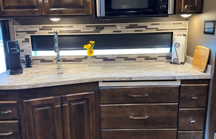kitchen area with large counter area covering sink and stovetop