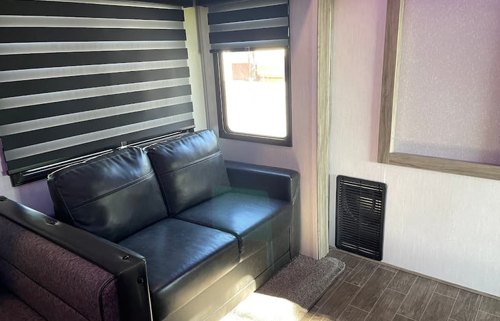 Couch in front of TV and fireplace will pull out into bed