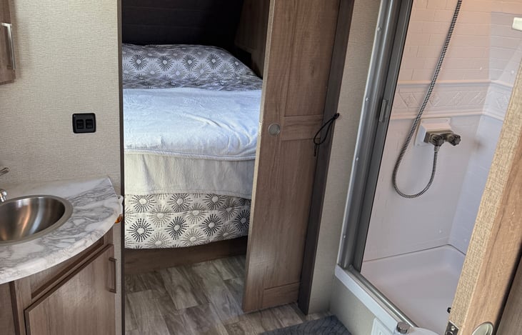 Spacious bathroom, with porcelain toilet, large shower that will accommodate someone 6'5" and a sink with mirror. There is also space for your toiletries.