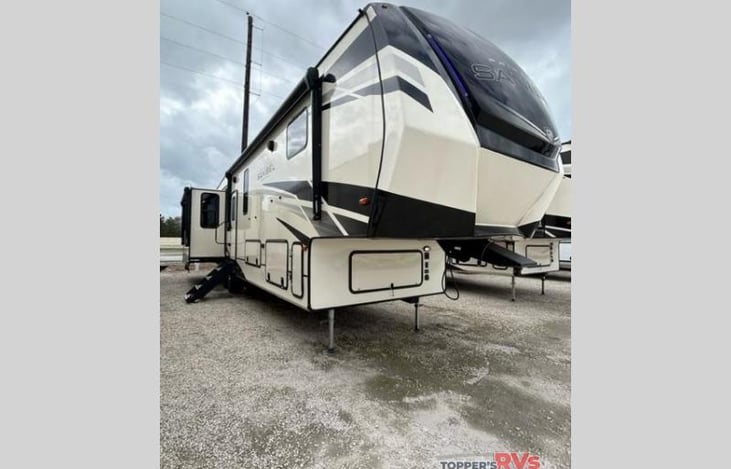 Outdoor kitchen with two large electric shades with lights, perfect for outdoor entertaining and relaxing