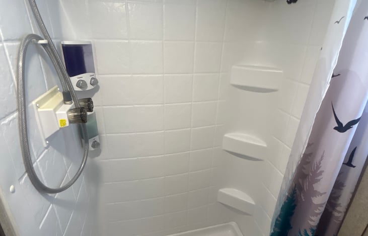 Stand in shower stocked with shampoo, conditioner and body wash