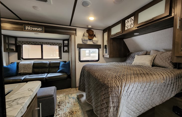 Living area with a residential size queen bed and a fold out couch