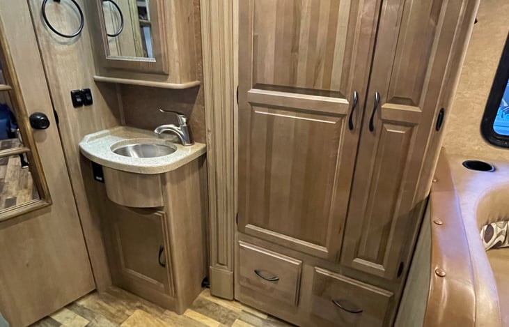 Bathroom sink is usable when the shower is occupied.