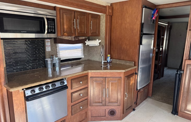 Fully functional kitchen with microwave/convection oven, 3 burner gas stove and a gas oven. Refrigerator/freezer combination unit.