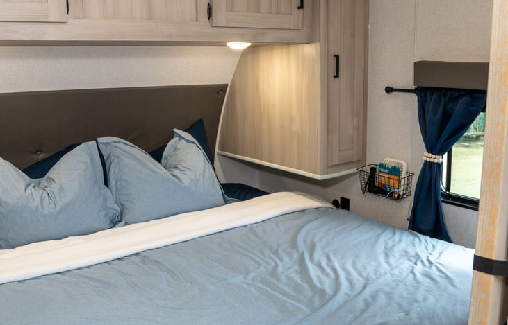 King sized bed with overhead storage and wardrobe cabinets on both sides. Plugs and USB ports on both nightstands.