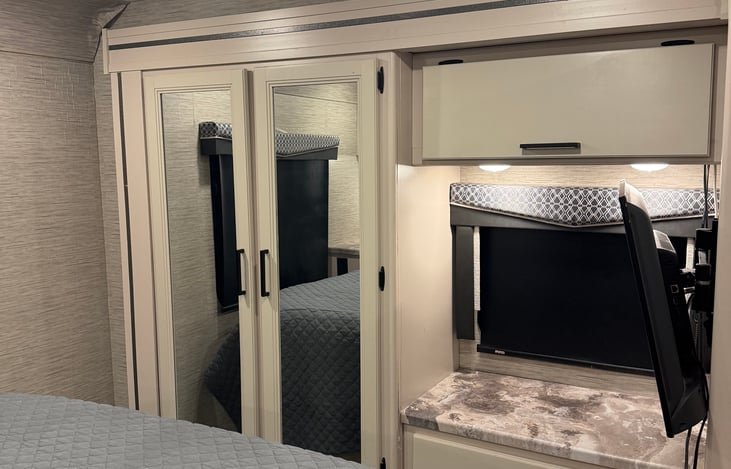 Queen room with smart tv and mirrors.