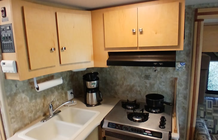 Full RV kitchen: 3 burner LP stove, microwave, double sink, coffee maker. All cabinets stocked with utensils and cooking gear!