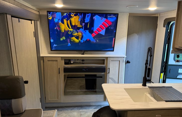 Living area with large 4K TV, soundbar and electric fireplace