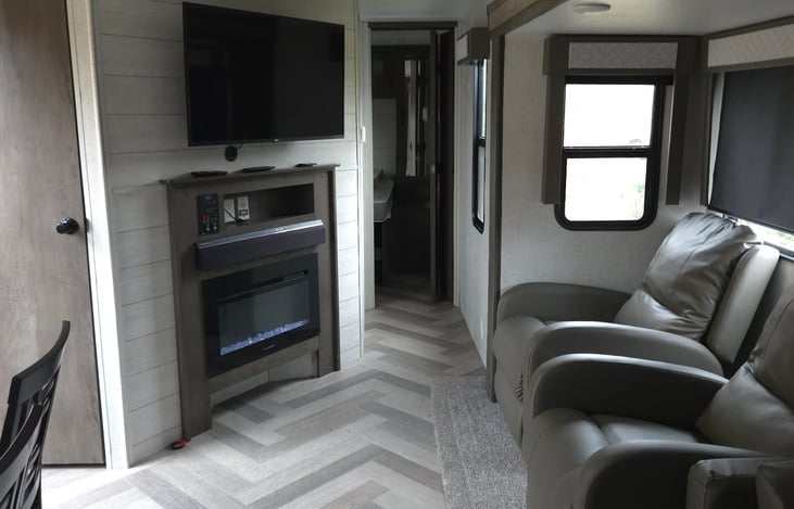 Living room with heating and non heating fire place, radio and surrond system and cozy recliners that are comfy enough to sleep in!