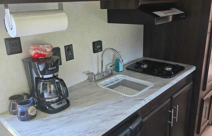 Counter space with coffee pot, sink and 2 burner stove
