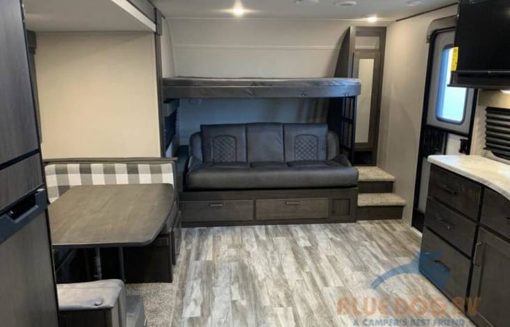 Couch folds down to make a bed. Upper bunk can be folded upright so it's not in the way.