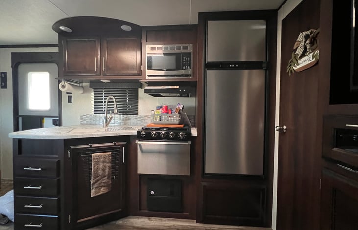 Kitchen has fridge, stove, oven, sink and microwave.