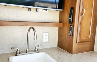 Large RV with outdoor kitchen, fireplace, and TVs