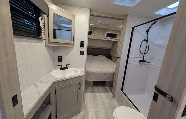 The walk-through bathroom has plenty of room for him and her to use the sink and shower at the same time. Instant hot water and a bright skylight make for an inviting shower.