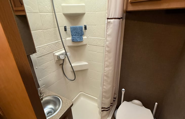 Private bathroom with shower, sink & toilet. 
Hot water heater can be operated by LP, generator or shore power.