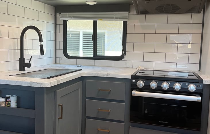 Kitchen includes deep stainless steal sink, microwave, gas stove. Fully stocked with plates, bowls, cups, utensils and pots/ pans.