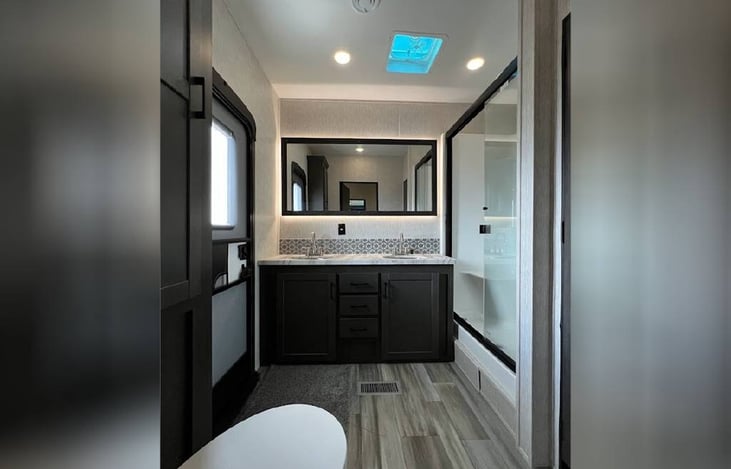 Double vanity in bathroom with exit door