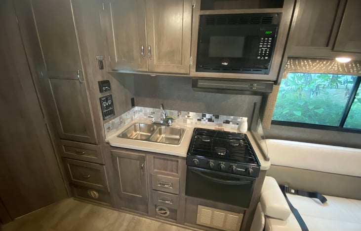 Kitchen set up. Double sink, stove, stovetop, range hood (with fan), microwave and storage! Many of those drawers include silverware, dishes, mugs, cups and kitchen tools.