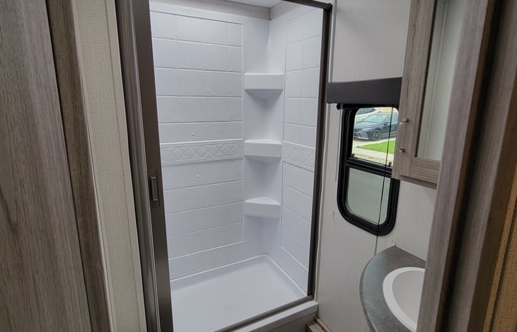 Full size bathroom with skylight and porcelain toilet.