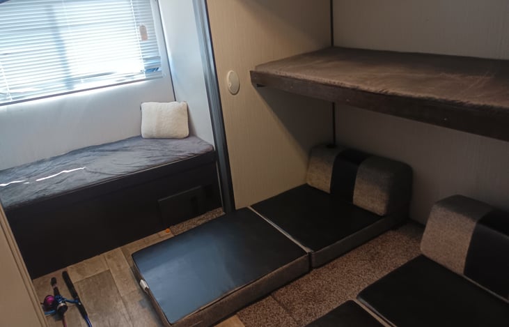 Back bedroom sleeps 5 on 3 twin fixed beds and 2 of the folding cushions twin size..  2 of 3  fixed beds and 2 folding cushions shown in picture.