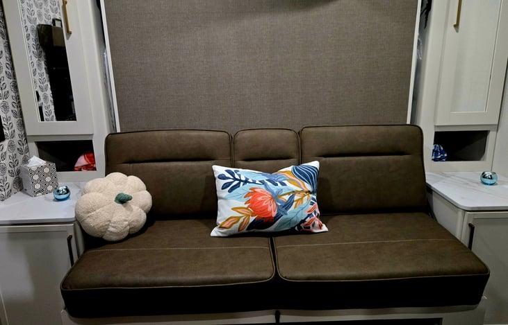 Couch with storage on both side, 1 side shelves other has area to hang clothes. There is a lap top desk, C port and outlets, above storage.