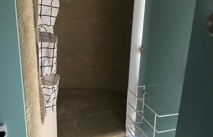 Storage closet with clothes rod with hangers.