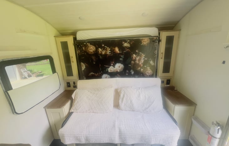 The couch when bed is up. Emergency window to the left. All windows have custom cut vinyl blackout shades.