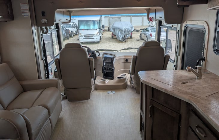 View from the kitchen to the front of the coach. Main slide is out, Lots of living space! The driver's seat is a bit threadbare, but we are planning on custom seat covers this fall....