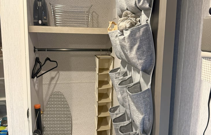 "Walk-in" closet with ironing board and iron.