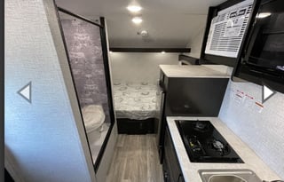 Yes it has a bathroom. Small easy to tow 3200lbs.