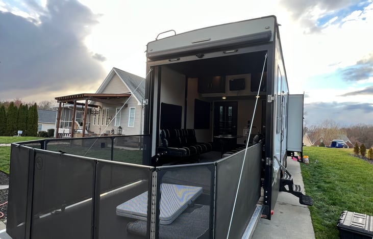 Rear patio with fence to contain children / pets; also has pull down screen top keep bugs out. At night, this will need to be folded up if guests are sleeping in the rear portion of the camper