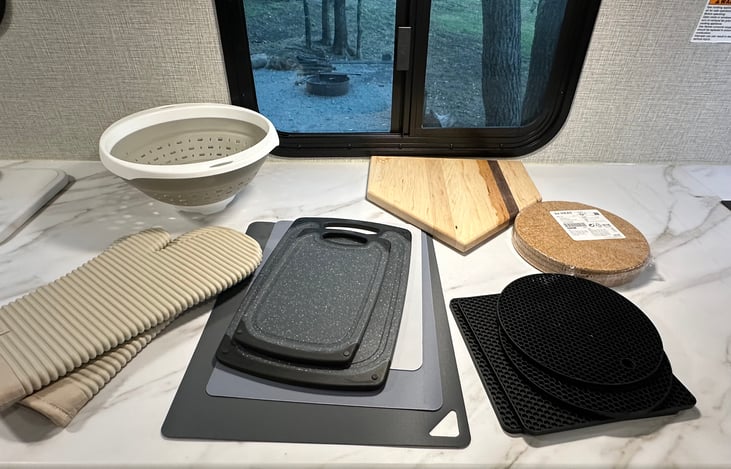 Cutting boards, hot plates, a strainer, and heat-resistant cooking mitts.