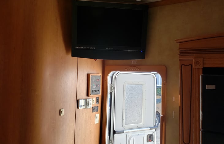 Main entry entering into kitchen. Flat screen tv over door and control center for camper.