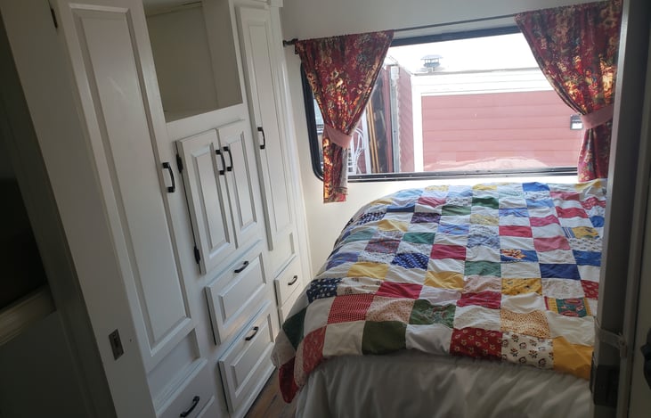 All white bright storage areas in the bedroom. Lights inside cabinets! The sliding-door closes off the bedroom for privacy.