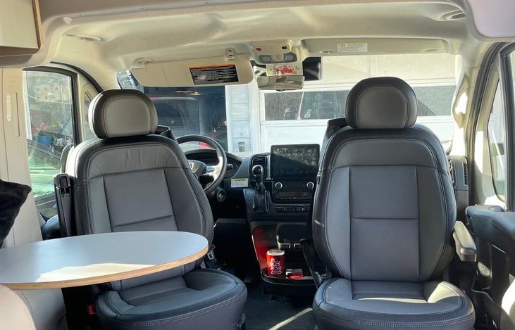 Additional storage is located above the cab area.
Both front seats swivel to face the rear. A removable table is located in front of the two passenger seats.