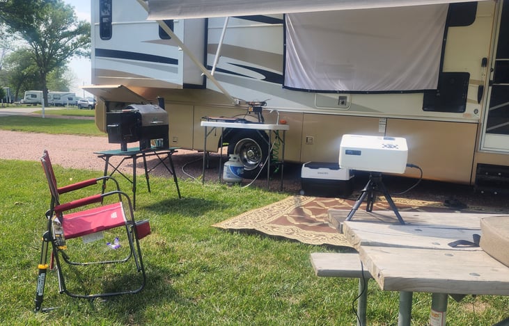 Fully stocked camping kitchen with Green Moutain Pellet grill, camping fridge, and stove burner. 
   Outdoor projector for movie nights