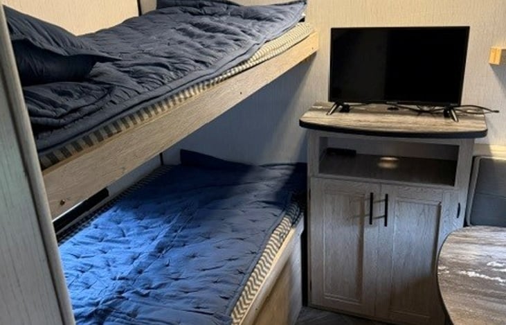 Rear bunk room with TV & 2 seat table. Pillows and bedding provided.