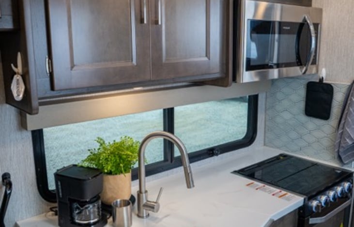 quartz countertops with sink cover and extra pop up counter make for additional counter space when needed.
