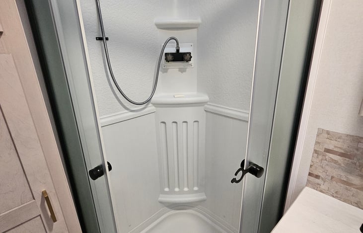 Spacious shower with a clear, open door