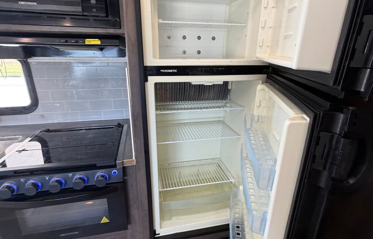 Efficient kitchen area equipped with a deep sink, high-rise faucet, and ample cabinet space.