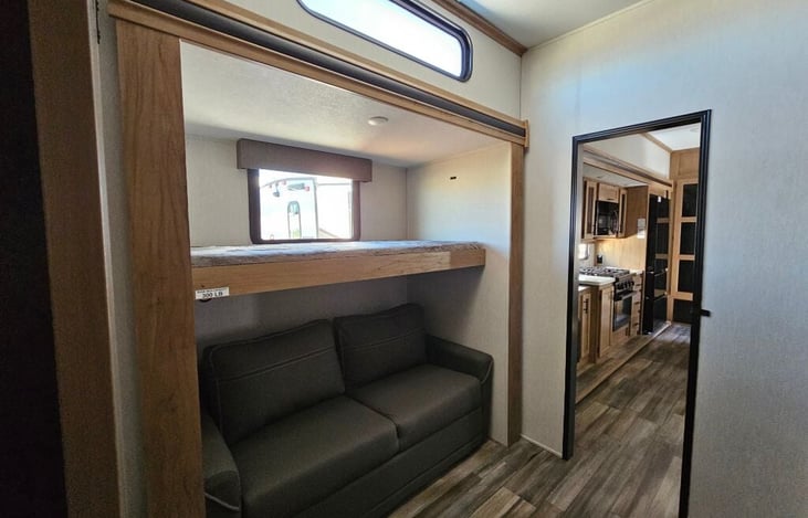 Bedroom 2/Bunk area. Includes sofa with makes full -size bed, bunk bed above couch, 2 more bunk in nest above storage area